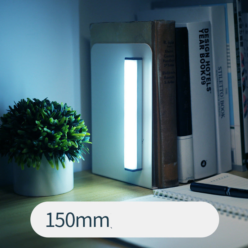 Small rectangular light on a desk next to books and a plant, with a '150mm' label.