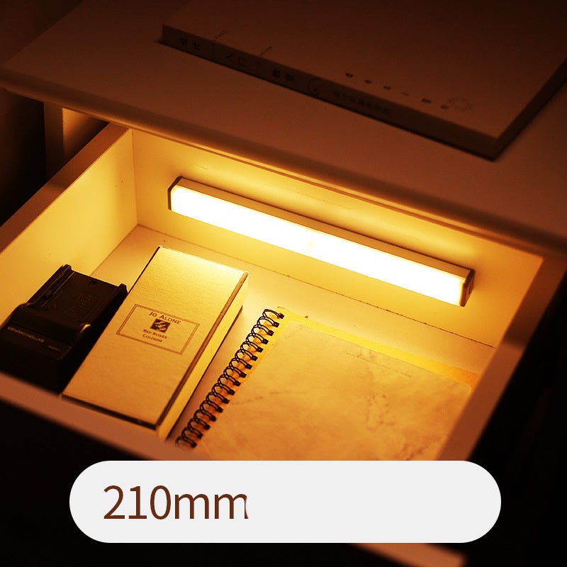 Lighted drawer with a notebook and pen, labeled '210mm'.